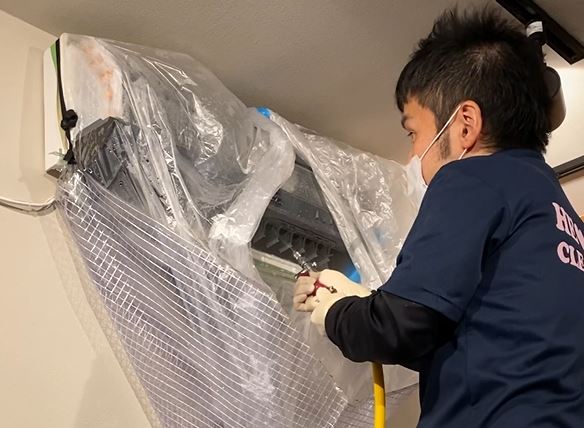 アルミフィンに向けて高圧洗浄ガンで噴射する様子