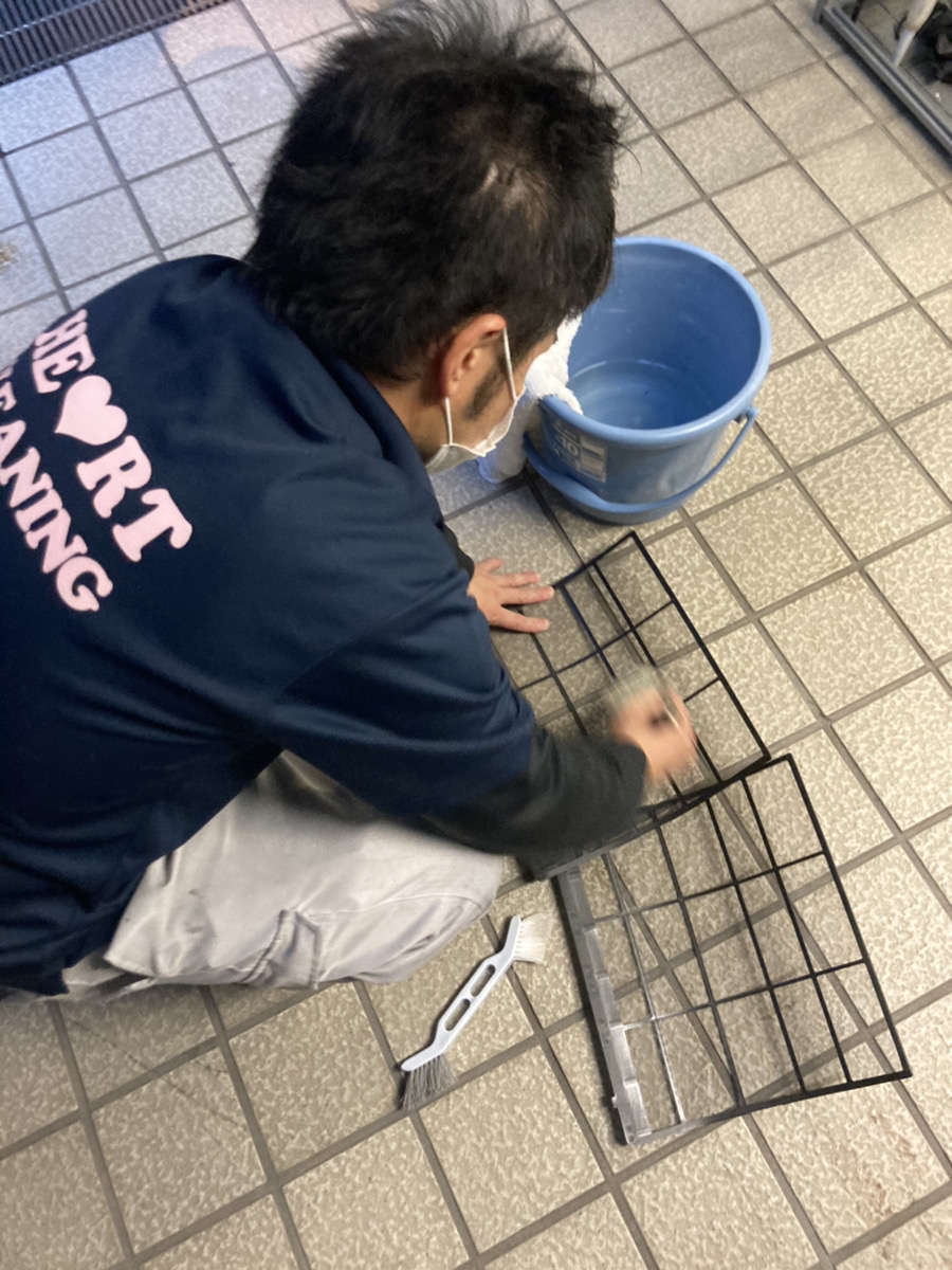 取り外したフィルターなどの部品を屋外で手洗いするスタッフ
