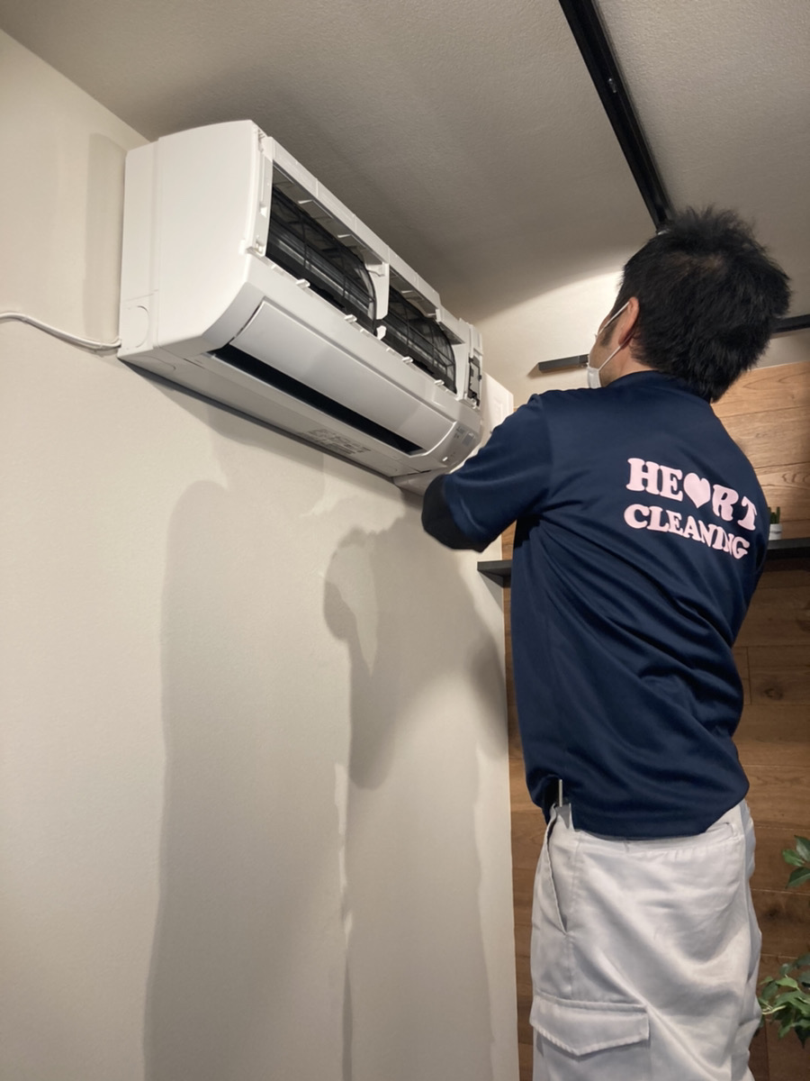 洗浄を終えたエアコンを組み立てるスタッフ